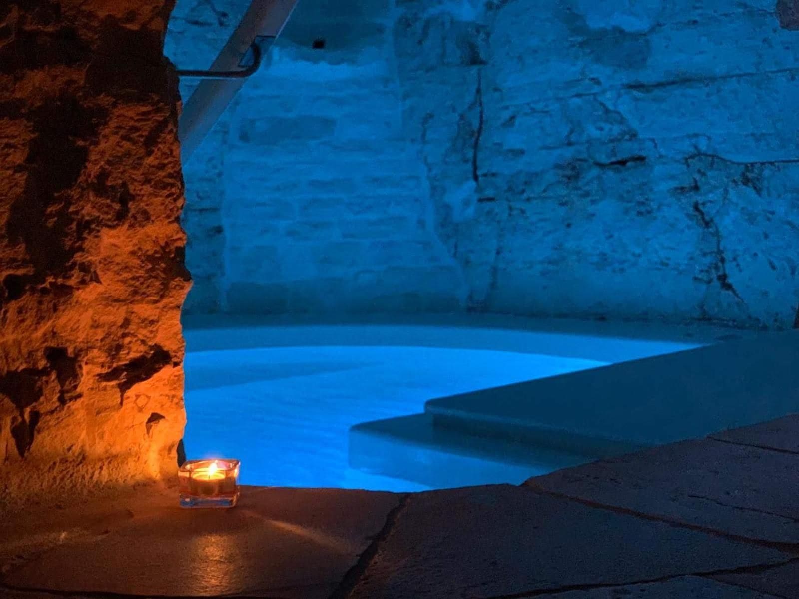 Un interno in pietra con una candela su un ripiano.