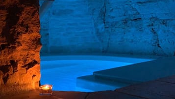 Un interno in pietra con una candela su un ripiano.