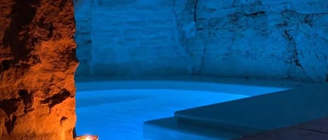Interior de piedra con una vela sobre un repisa.