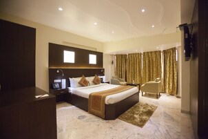 Una habitación de hotel moderna con una cama grande, un escritorio y una zona de estar.