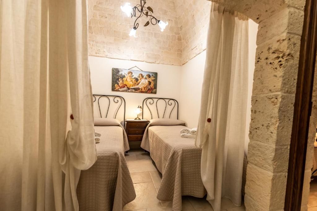 Una habitación con dos camas, un cuadro en la pared y una araña.