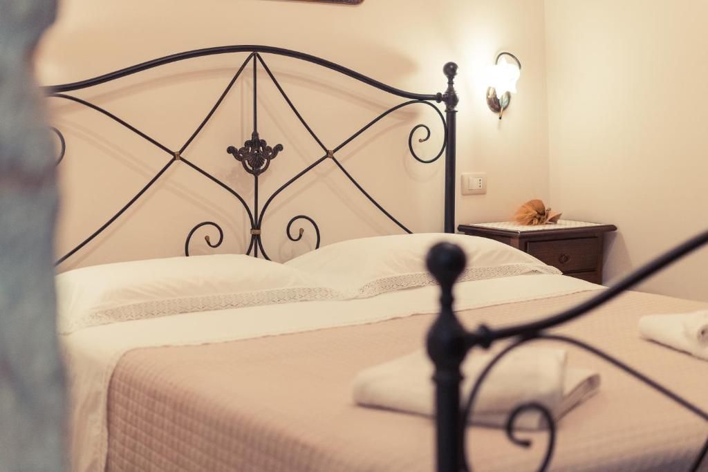 A bed with a metal frame, a bedside table, and a wall-mounted light fixture.