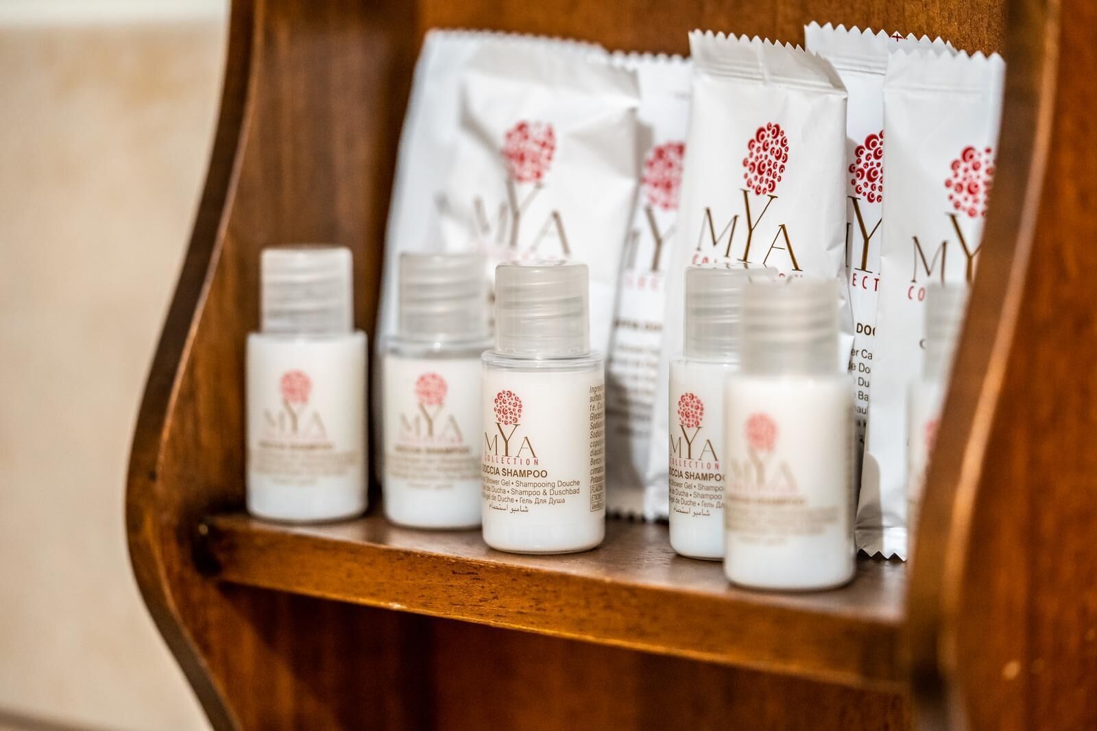 A wooden shelf with several bottles of Mya Collection hair care products.