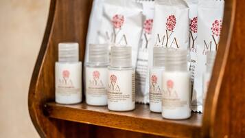 A wooden shelf with several bottles of Mya Collection hair care products.
