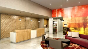 Eine moderne Lobby mit Empfangstresen, Sitzbereich und farbenfroher abstrakter Wand.
