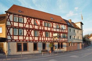 Ein traditionelles Fachwerkhäuschen mit vielen Fenstern und einem geneigten Dach.