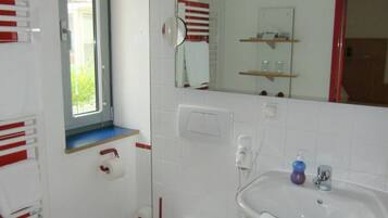 Un baño pequeño con inodoro, lavamanos y espejo.