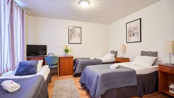Una habitación de hotel con dos camas, televisión, escritorio y una silla.