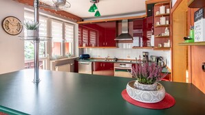 A modern kitchen with red cabinets, a black countertop, and a decorative plant centerpiece. - are you looking for relaxation, action and culture? (Paszkowka)
