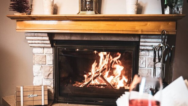 A cozy living room with a fireplace, a clock above it, and a person reading a book. - are you looking for relaxation, action and culture? (Paszkowka)