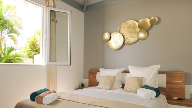 Ein Hotelzimmer mit einem Bett, einem Nachttisch, einem Spiegel und einer Wanddekoration.