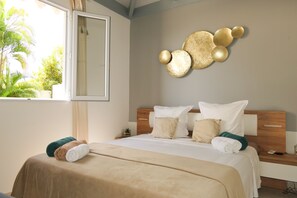 A hotel room with a bed, a nightstand, a mirror, and a wall decoration.
