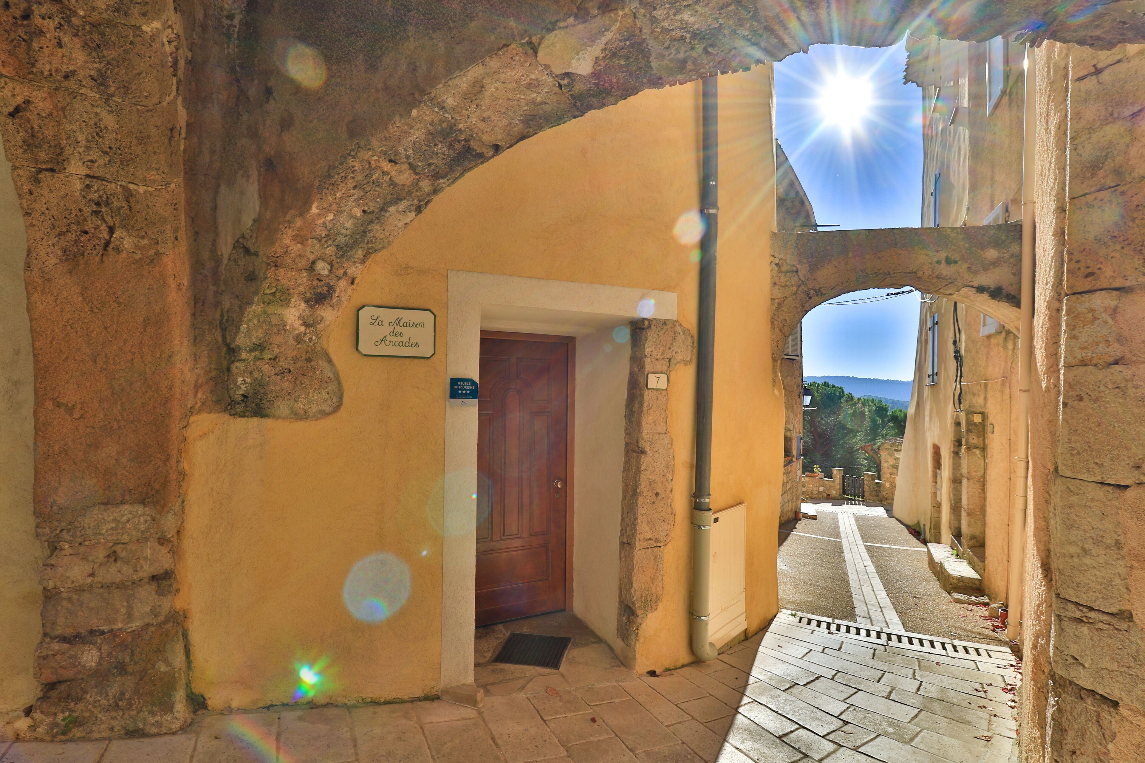 An arched doorway leading to a building with a sign that reads "Lo Chien de la Cueva de los Muertos."