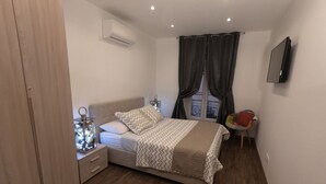 A bedroom with a bed, bedside table, lamp, and a TV mounted on the wall. - Rigoletto Massena hyper center, 5 min beaches (Nice)