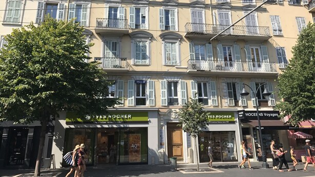 A multi-story building with storefronts on the ground floor, including Yves Rocher and Hoche's Voyages. - Rigoletto Massena hyper center, 5 min beaches (Nice)