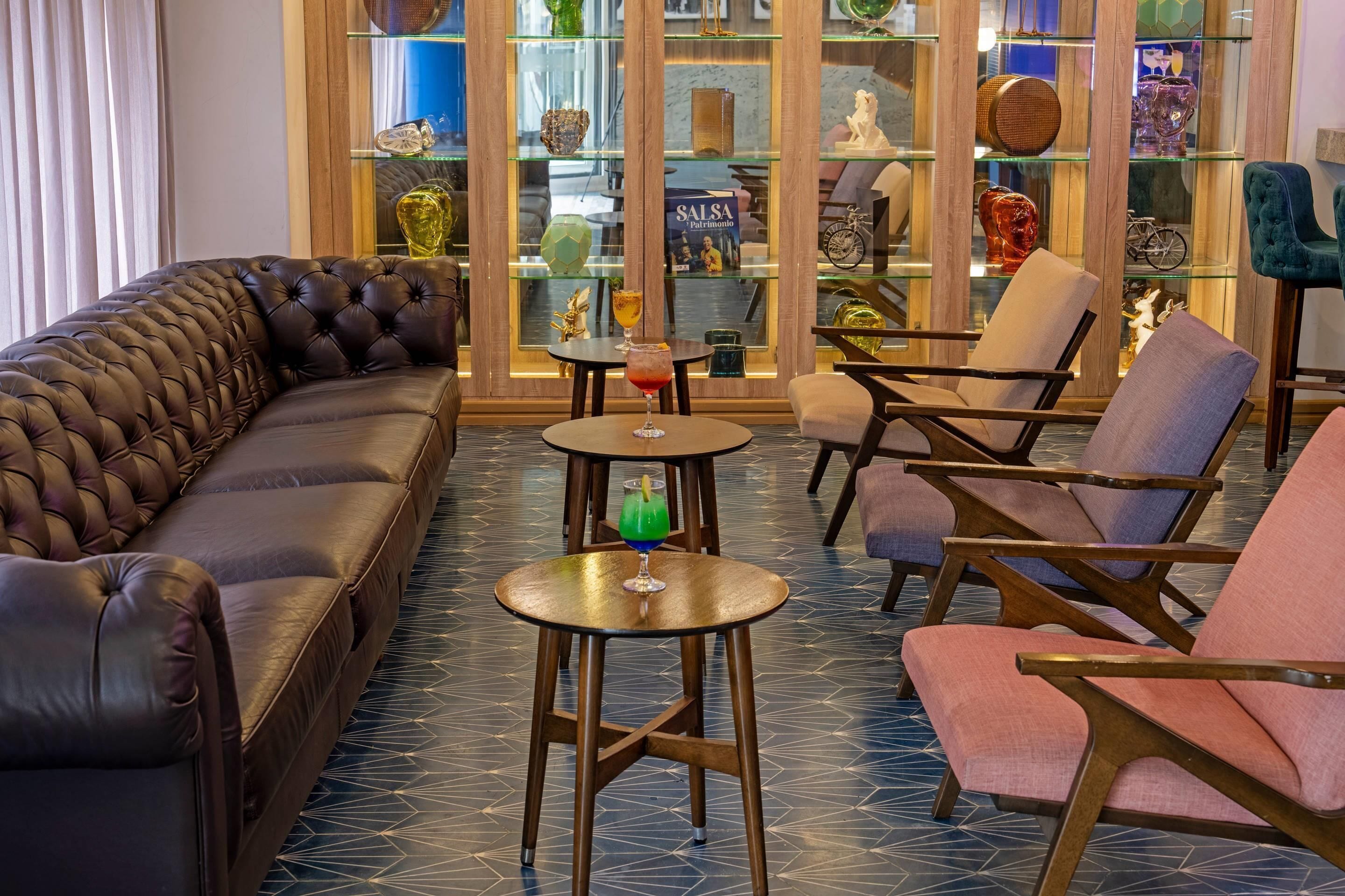 Eine moderne Lounge mit einer Ledersofa, Sesseln und einer Vitrine mit Dekorationselementen.