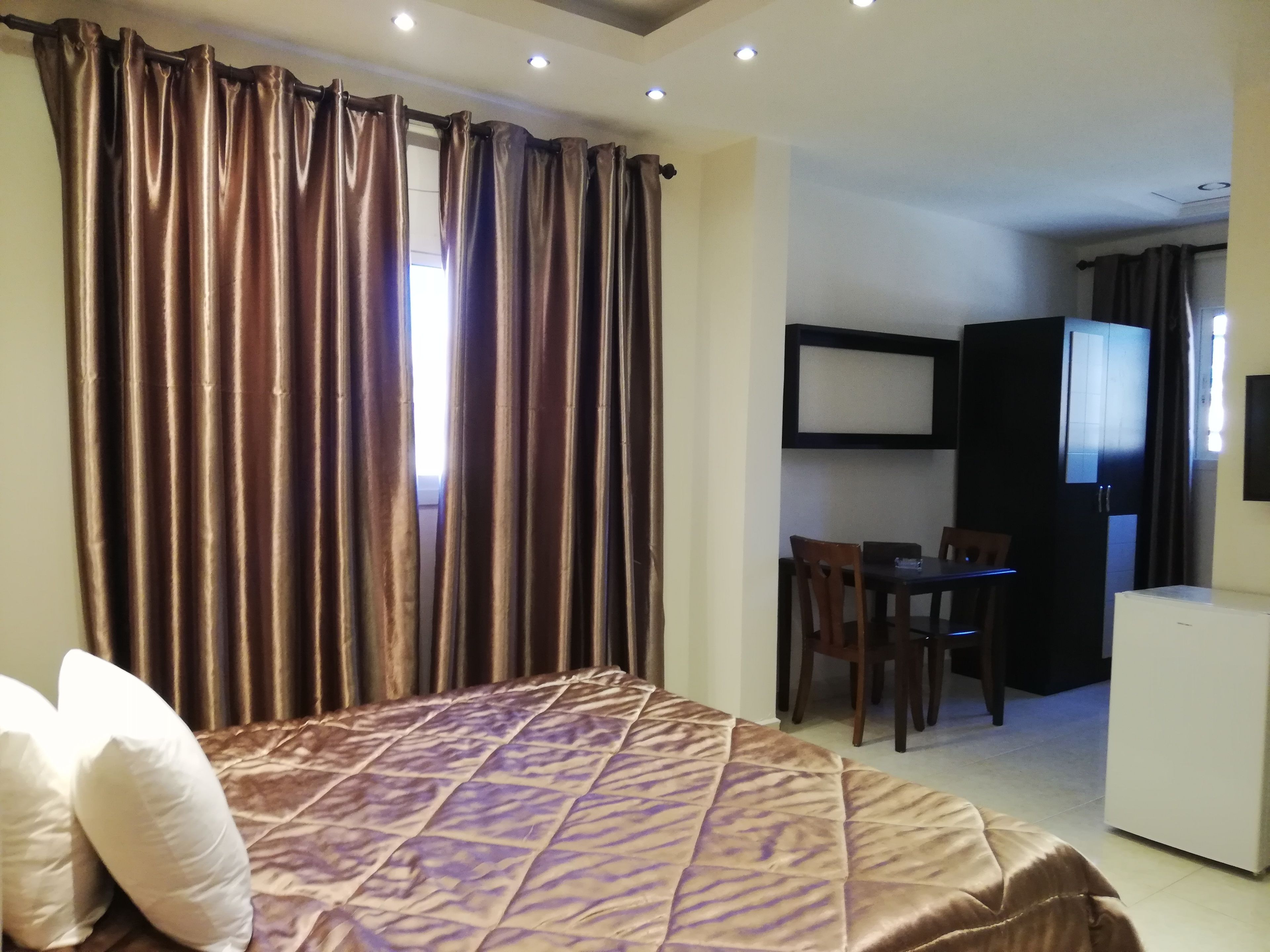 Habitació d'hotel amb llit, escriptori i televisió.