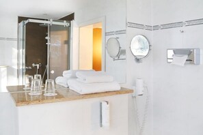 A modern bathroom with a glass shower enclosure, a vanity with a mirror, and a towel rack.