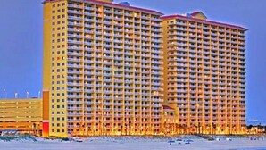Un hotel grande con varios pisos y balcones, cerca de la playa.