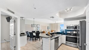 Una cocina moderna con armarios blancos, una isla central y electrodomésticos de acero inoxidable.