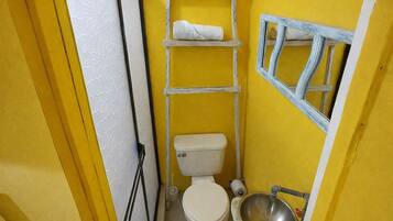 Un baño pequeño con inodoro, lavamanos y un perchero para toallas.