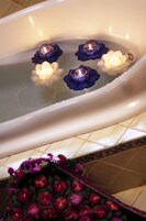 Una bañera con velas en forma de flores.