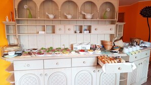 A buffet setup with various food items and condiments. - Waldhaus Lauenhain (Mittweida)