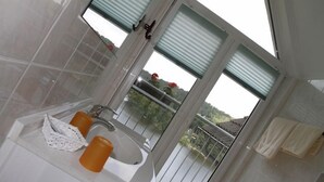 A bathroom with a large window, a sink, and a towel rack. - Waldhaus Lauenhain (Mittweida)