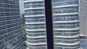 A modern high-rise building with a curved facade and multiple balconies. - Li'ao Apartment Hotel (NANTONG)