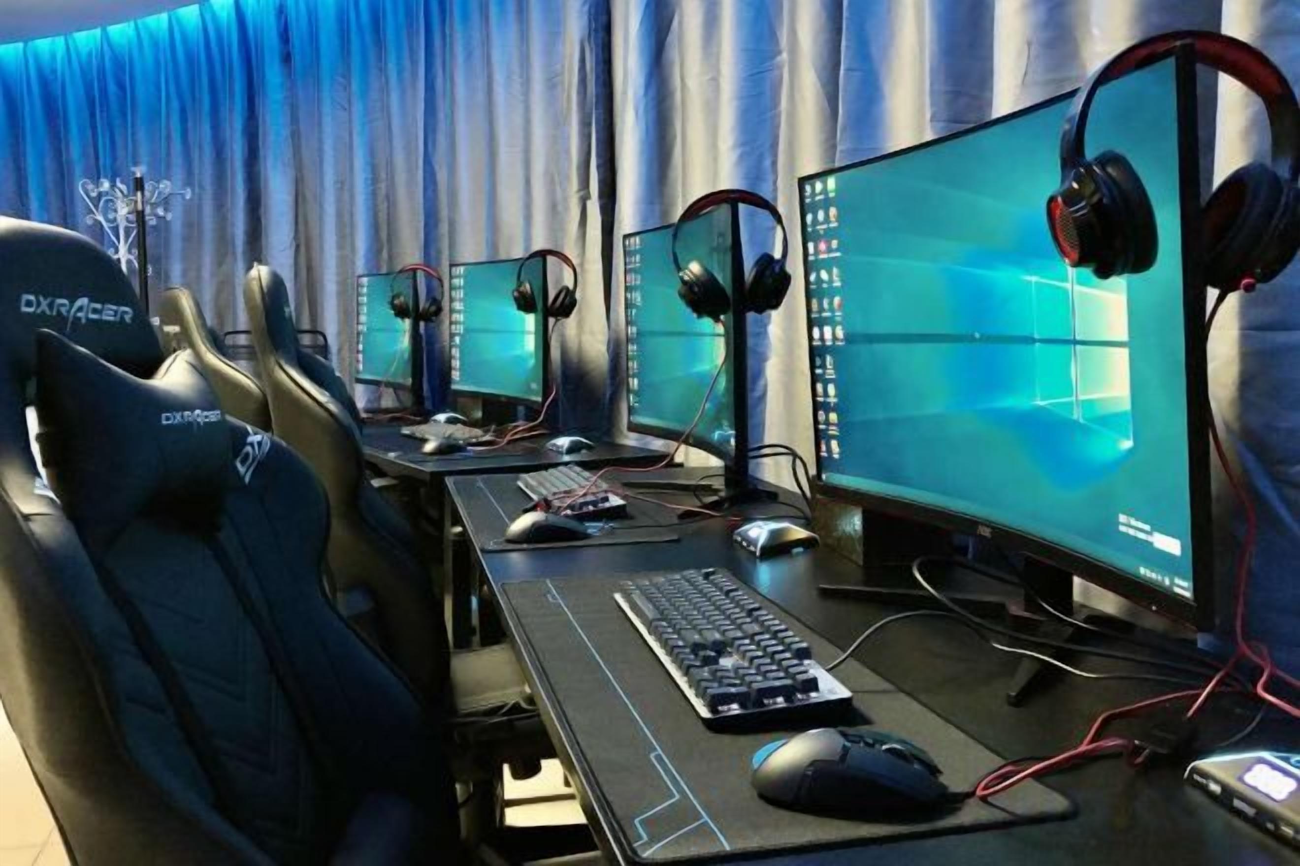 A gaming setup with multiple monitors, a keyboard, mouse, and headphones.