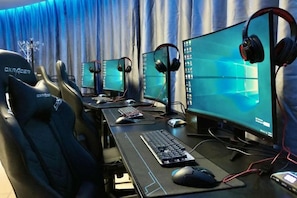 Configuración de juegos con múltiples monitores, teclado, ratón y auriculares.