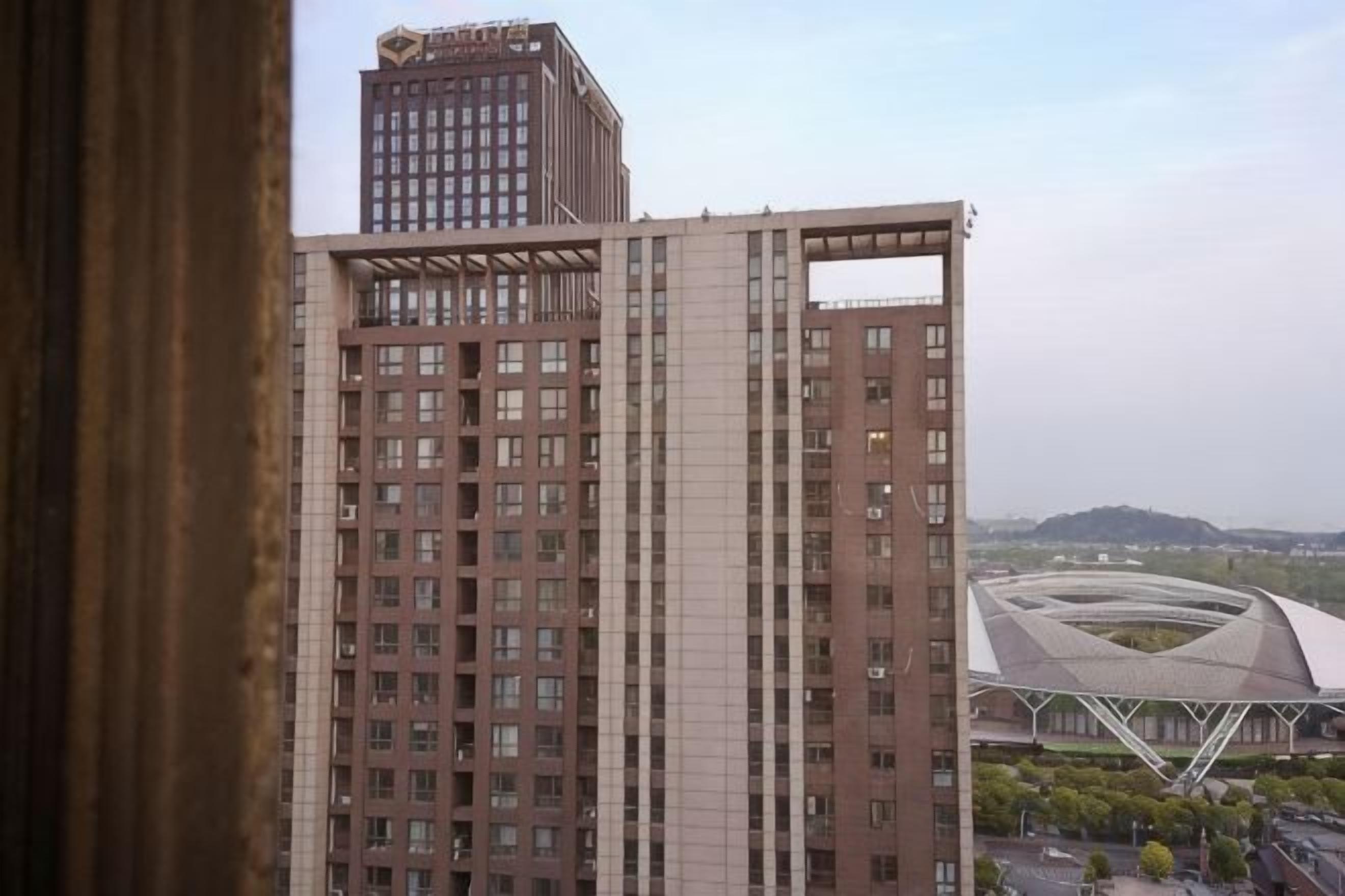 A high-rise building with a modern architectural design, featuring a grid of windows and a prominent vertical structure.