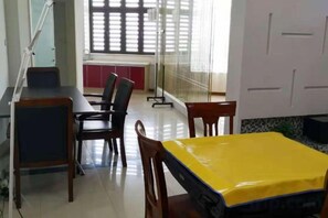 A conference room with a table covered in yellow, a whiteboard, and a window with blinds.