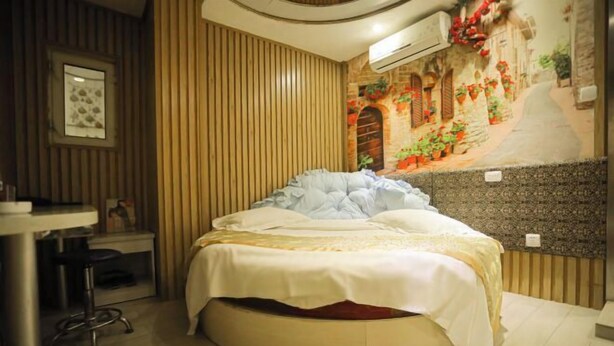 A room with a round bed, a small desk, and a wall mural. - Shell Chain Hotel (Mudanjiang North Railway Station Guangsha Branch) (Mudanjiang)