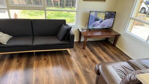 A living room with a black sofa, a brown leather couch, and a wooden coffee table.