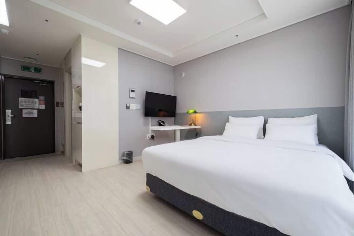 Roupas de cama premium, frigobar, espaço de trabalho para notebook