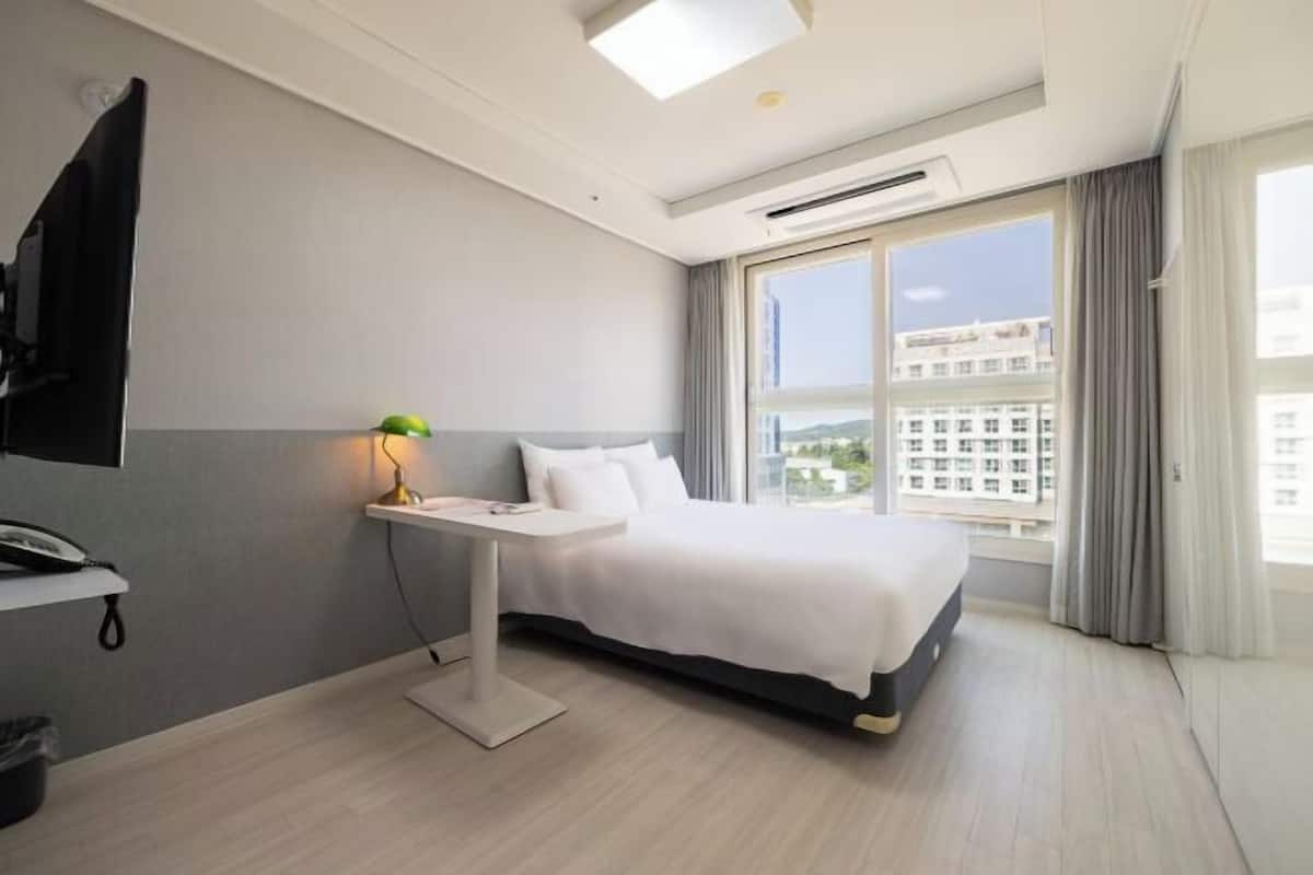 Roupas de cama premium, frigobar, espaço de trabalho para notebook