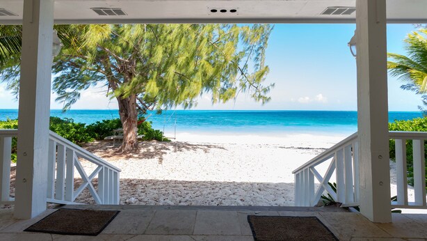 Un espacio al aire libre techado con vista a una playa y el océano.