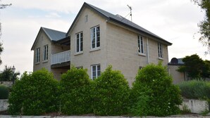 A two-story house with a balcony, surrounded by dense greenery. - The luxury guest house Busselton (Busselton)