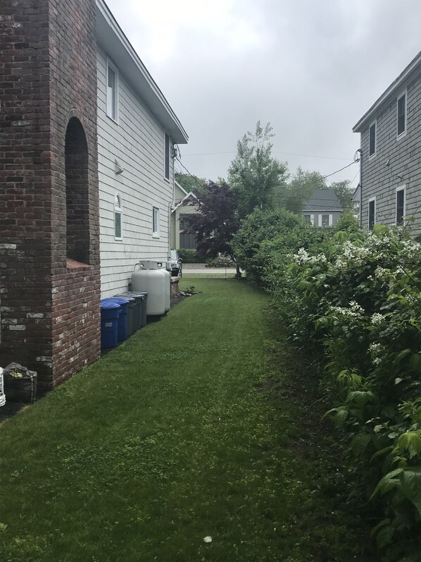 A residential area with a grassy yard, a brick building, and a white house with a garage. - Spacious Home, 3 minute walk to Moody Beach & Views of Rachel Carson Reserve (Wells)
