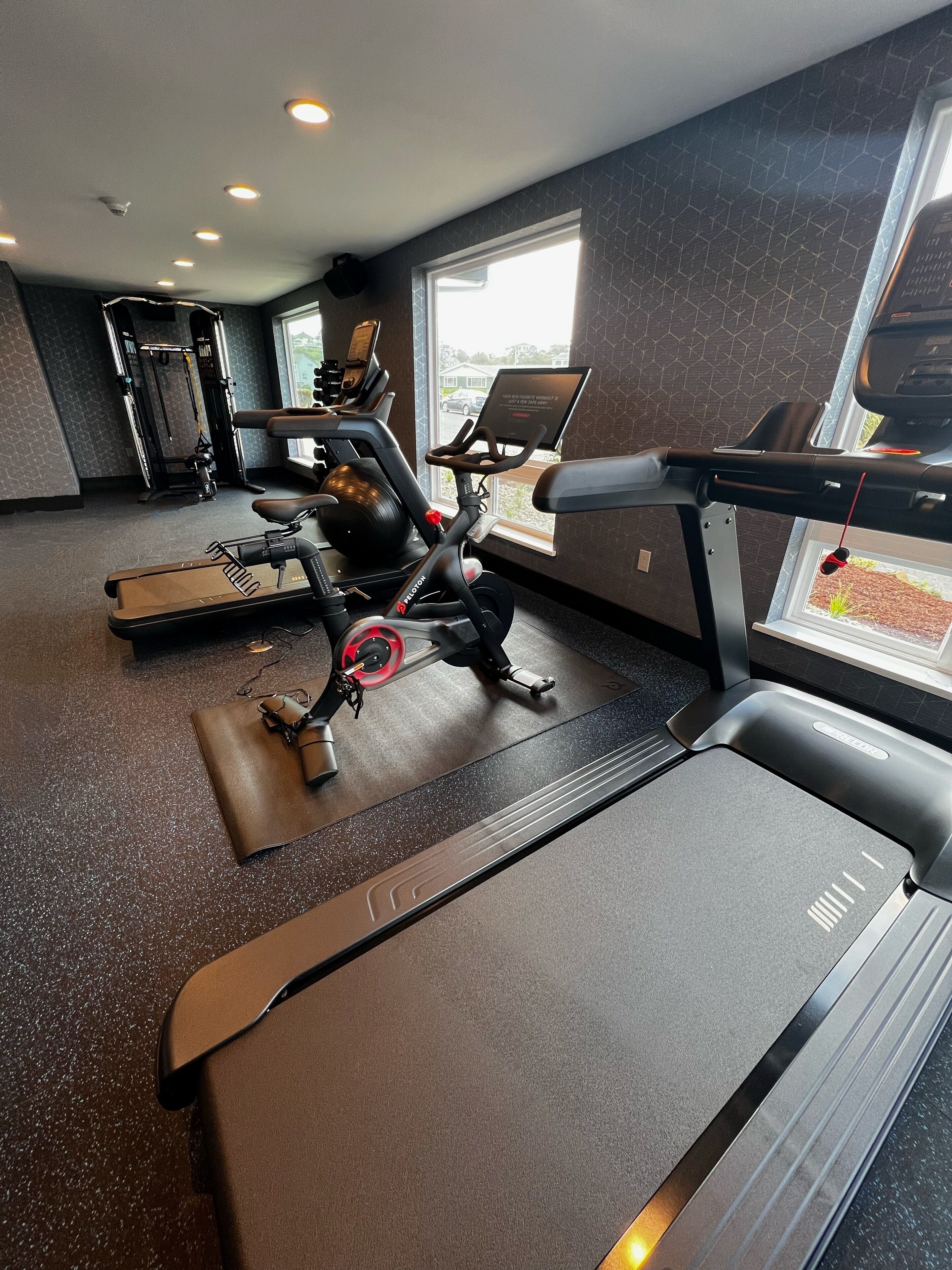 Ein Fitnessraum mit Laufband, Ergometer und Krafttrainingsgeräten.