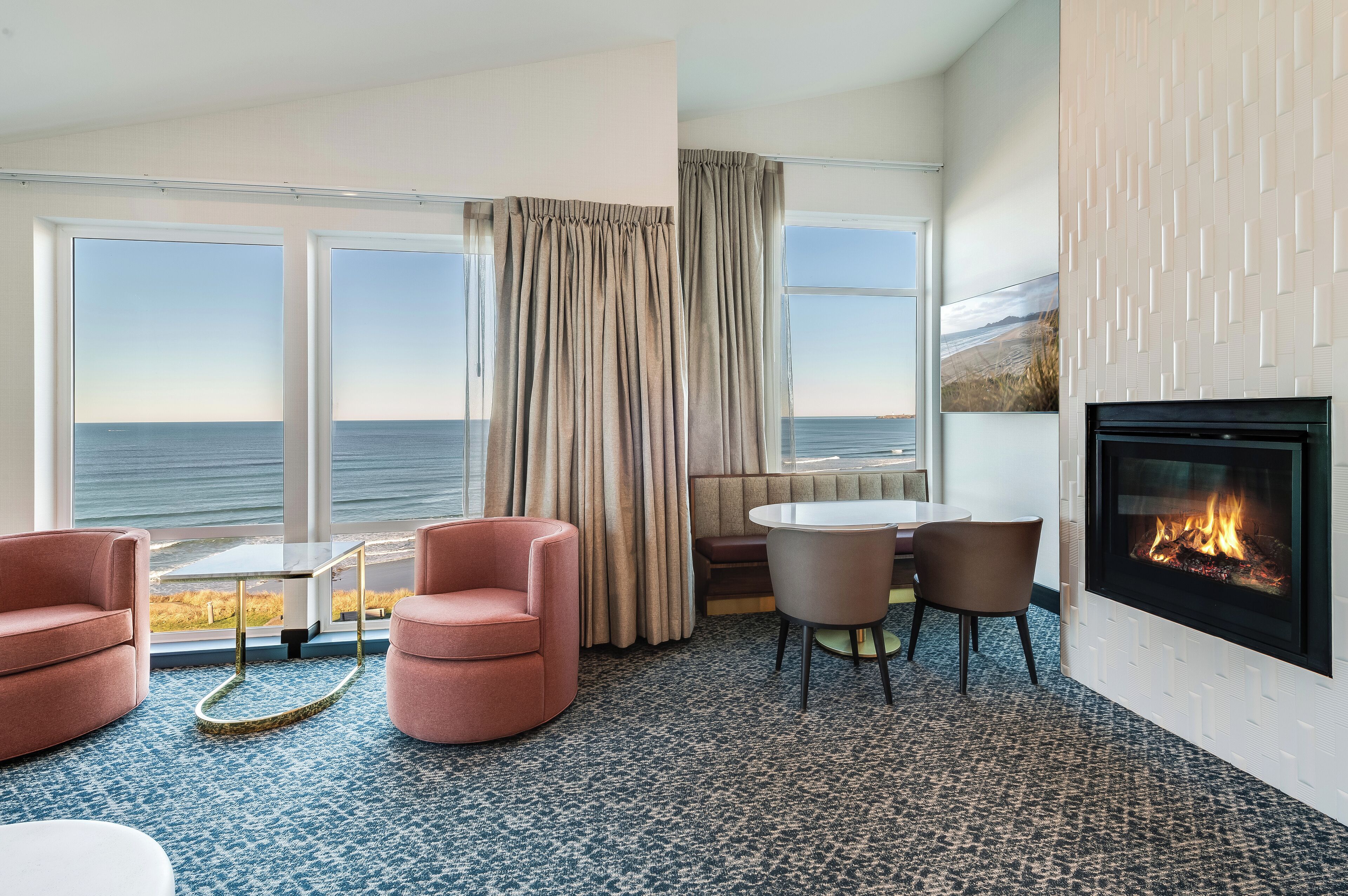 A room with a fireplace, a round table, and two chairs.