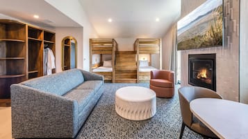A modern living room with a sofa, ottoman, and a fireplace.