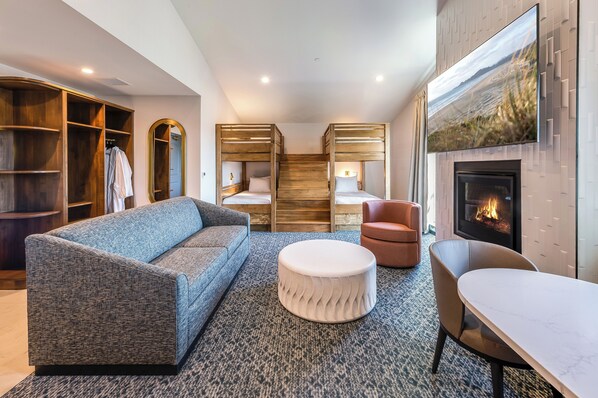 Una sala de estar moderna con un sofá, un reposapiés y una chimenea.