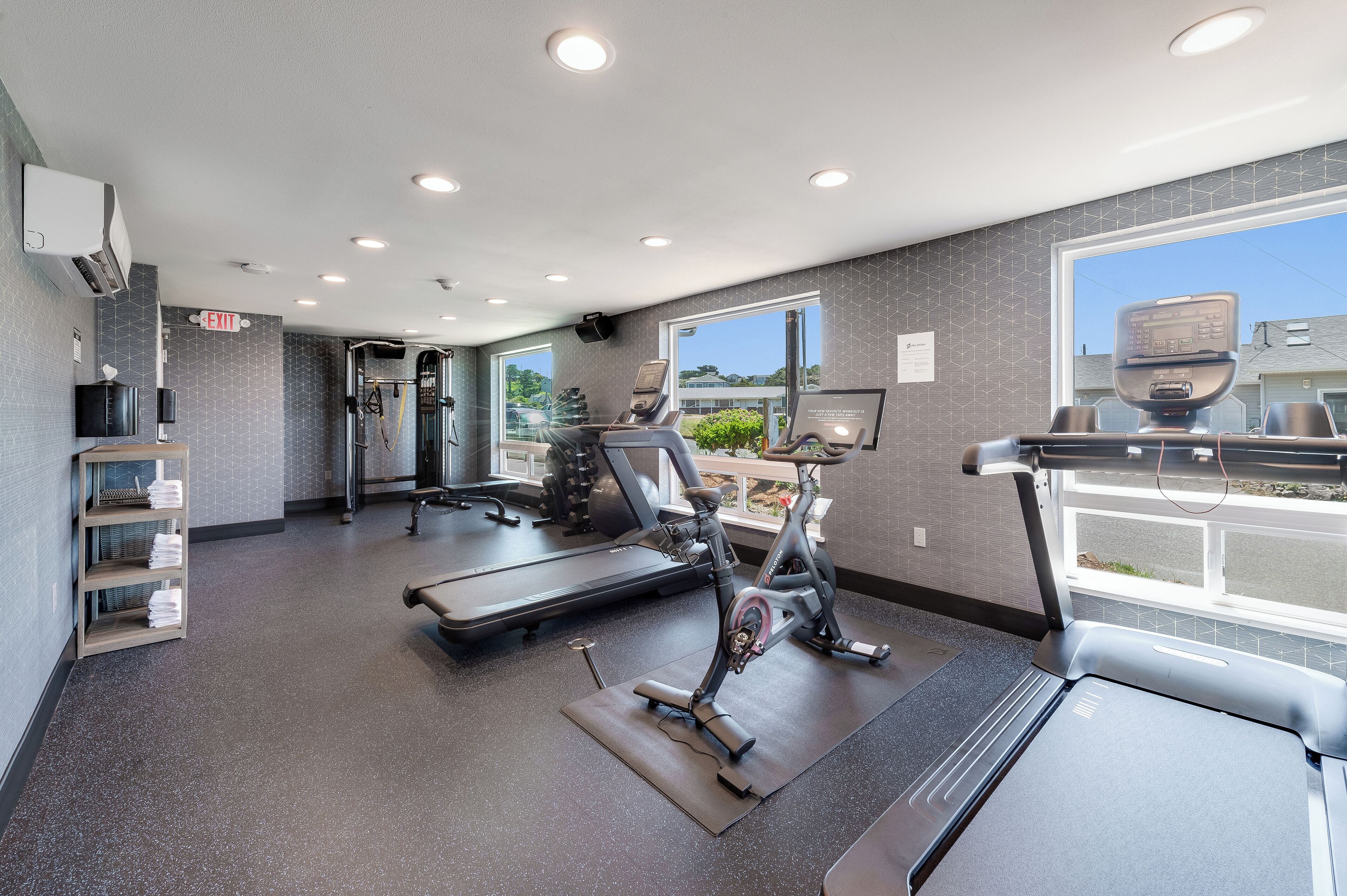 A modern gym with treadmills, stationary bikes, and weight machines.