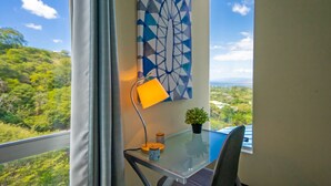 A room with a glass table, a lamp, a potted plant, and a geometric painting on the wall. - Stunning Oceanview Villa, Private Jacuzzi, 3 bedrooms, minutes from downtown (Playas del Coco)