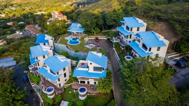 A residential complex with multiple houses, a swimming pool, and a hot tub. - Stunning Oceanview Villa, Private Jacuzzi, 3 bedrooms, minutes from downtown (Playas del Coco)