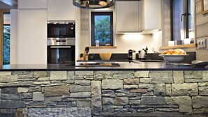 A modern kitchen with a stone countertop, built-in appliances, and a large window. - Contemporary chalet, close to centre of Chamonix (Chamonix)