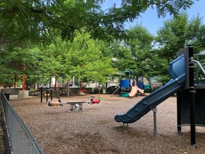 A playground with a slide, swings, and a climbing structure. - Charming Carriage House In Prospect New Town (Longmont)