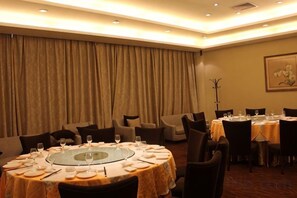 A dining area with round tables, chairs, and a large curtain backdrop. - ZTE Hotel, Nanjing (Nanjing)